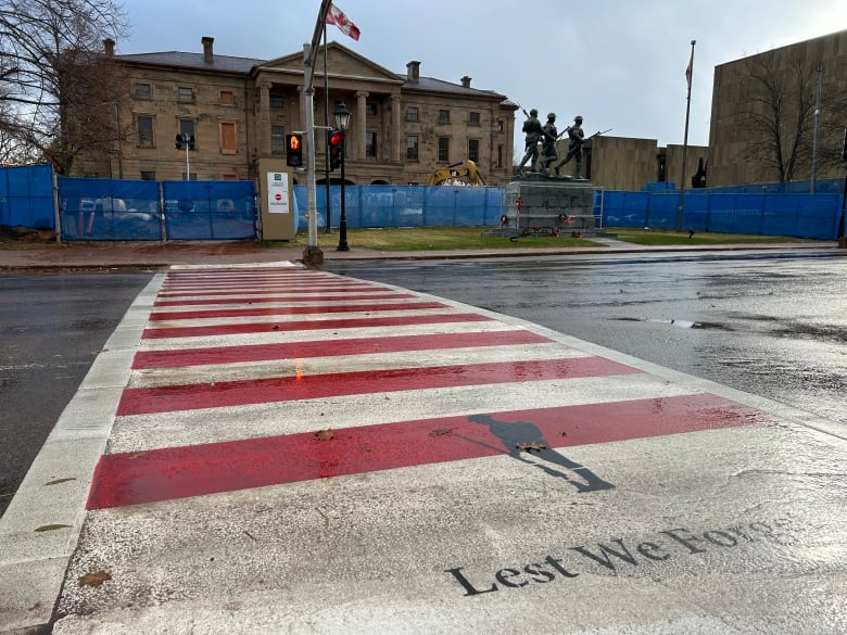 Crosswalk painted in red and white stripes.