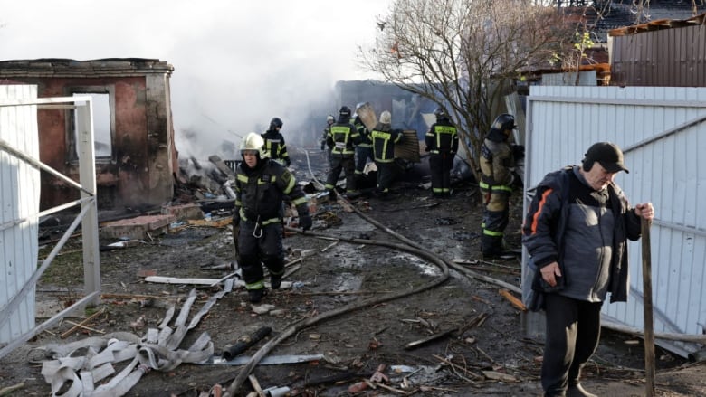 Rescuers clean debris in the courtyard of a house.