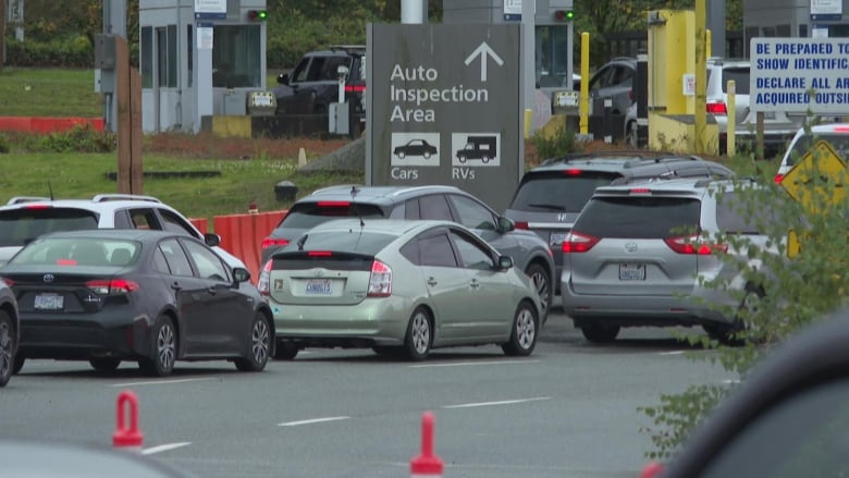 cars wait in a lineup below a sign