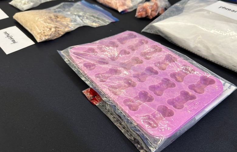 a table with a pink silicone dog bone mould used for making dog treats