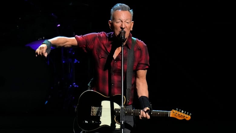 A man plays guitar on a stage