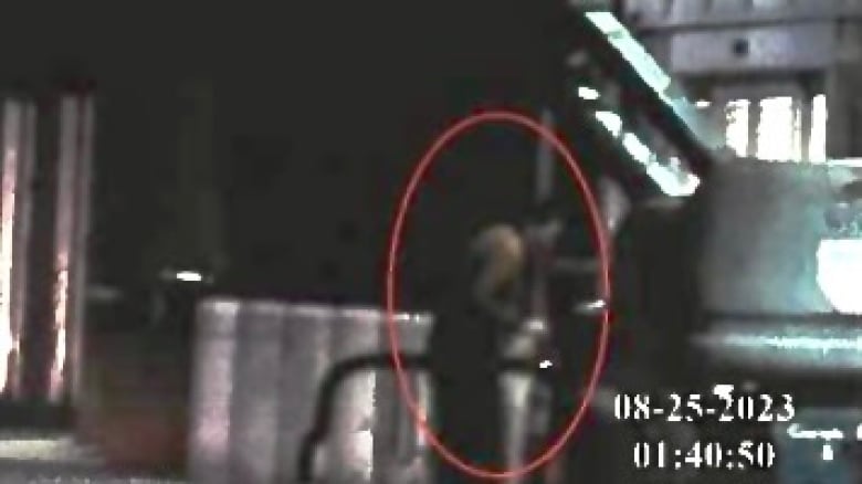 A red circle is drawn around a shadowy video of the blurred-out figure of a man bending over near an outdoor stairwell.