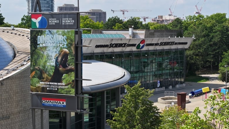 Photo of a sign advertising dinosaur exhibit outside Ontario Science Centre