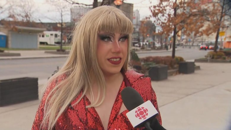 Photo of a woman with blonde hair and red sequin blazer