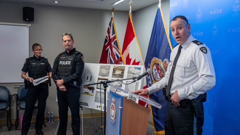 Three police officers at a police press conference.