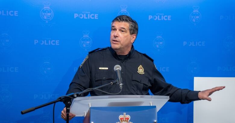 A police officer gestures toward a display at a news conference.