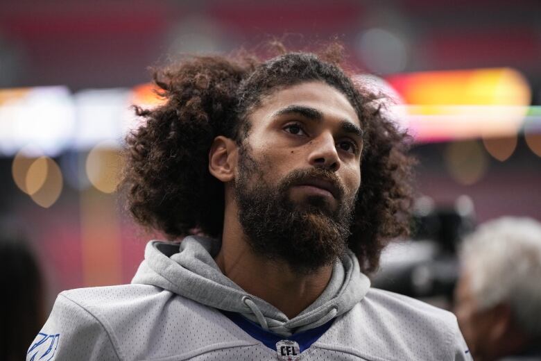 Head-and-shoulders shot of a young man with shaggy black hair and a beard.