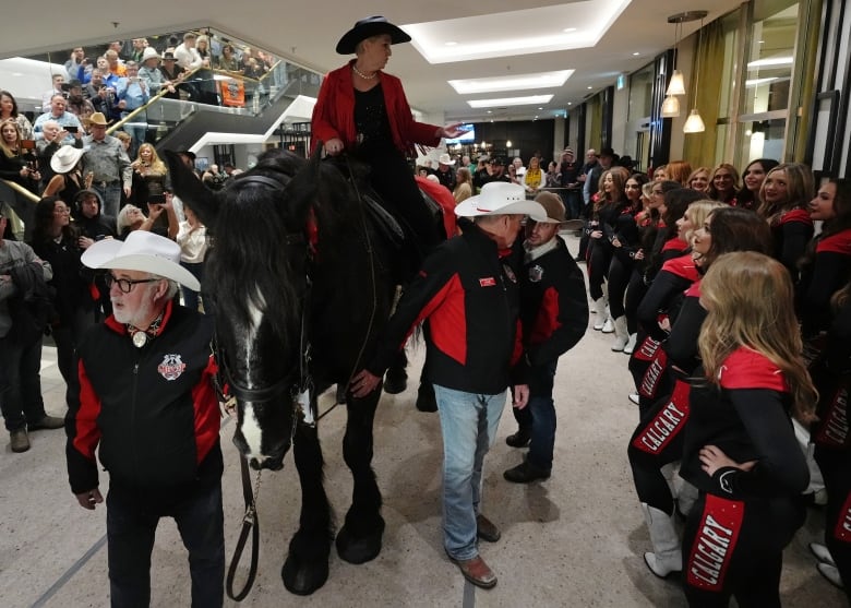 A woman rides a horse into the lobby of a hotel in downtown Vancouver.