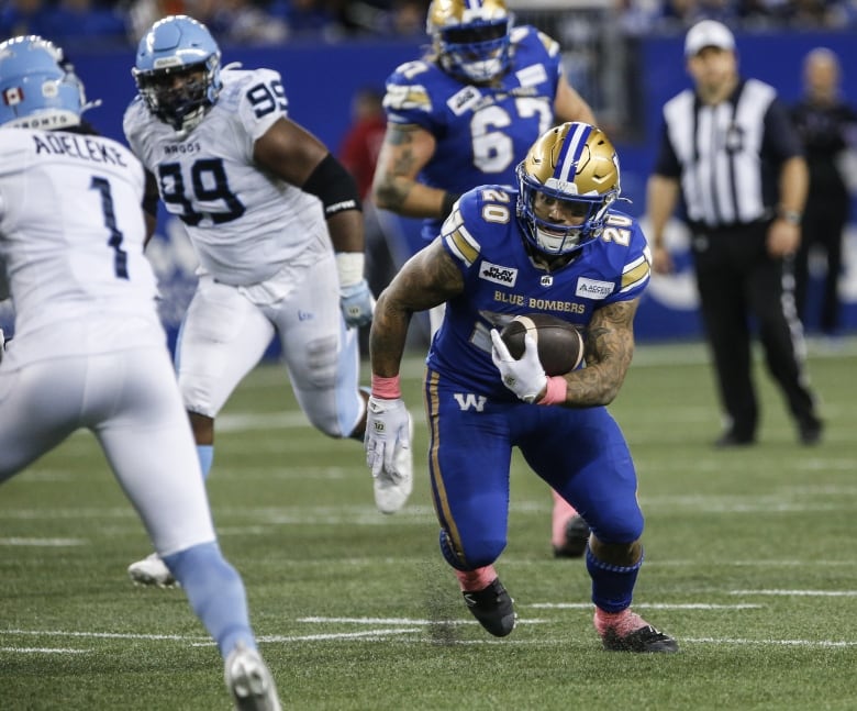 A football player tries to avoid a tackle.