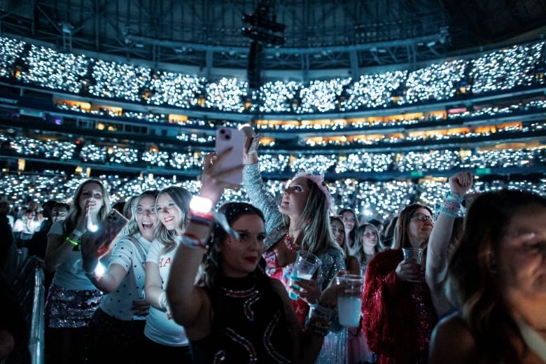 Happy fans in the audience taking selfies and listening to Taylor Swift at the first of six sold-out concert shows in Toronto.