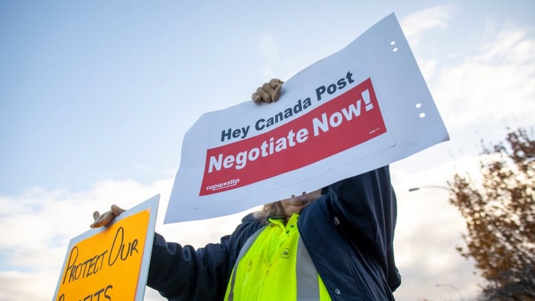 A person holds up a sign that says 