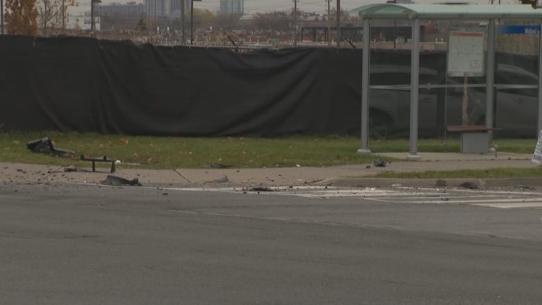 debris on the ground beside a bus stop and a sidewalk