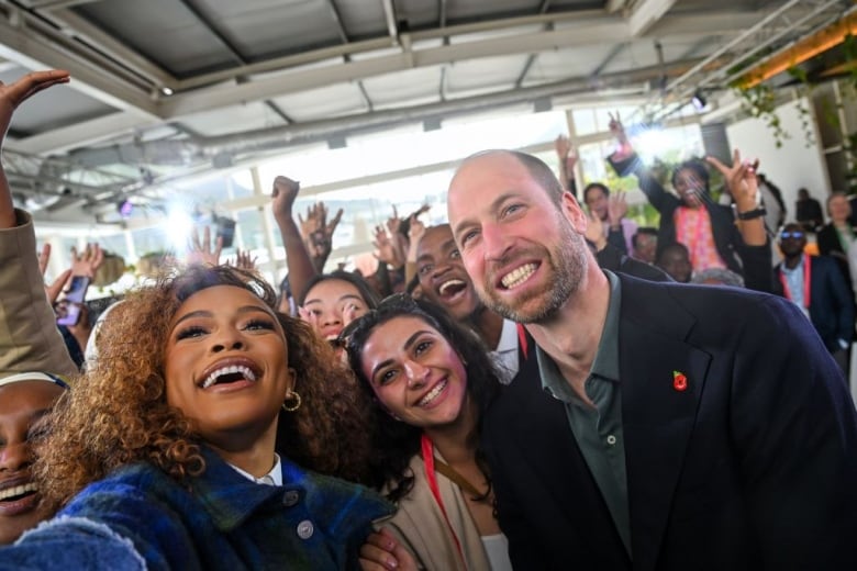 People smile as a person takes a selfie.