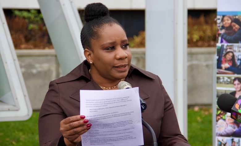 A person speaks into a mic outdoors. 