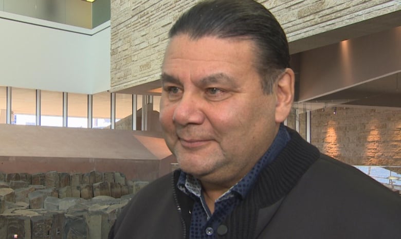 An Indigenous man smiles at the camera.