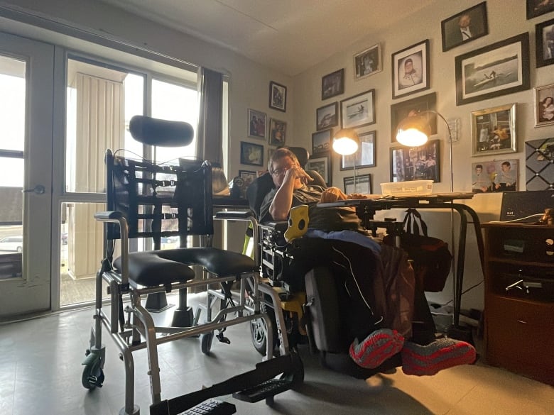 A man in a wheelchair at right, looks at his new assistive device--a water wheelchair.