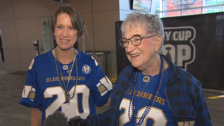 Two ladies in blue jerseys are interviewed.