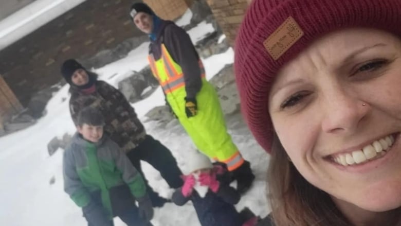 A family poses for a selfie on a snowy day.