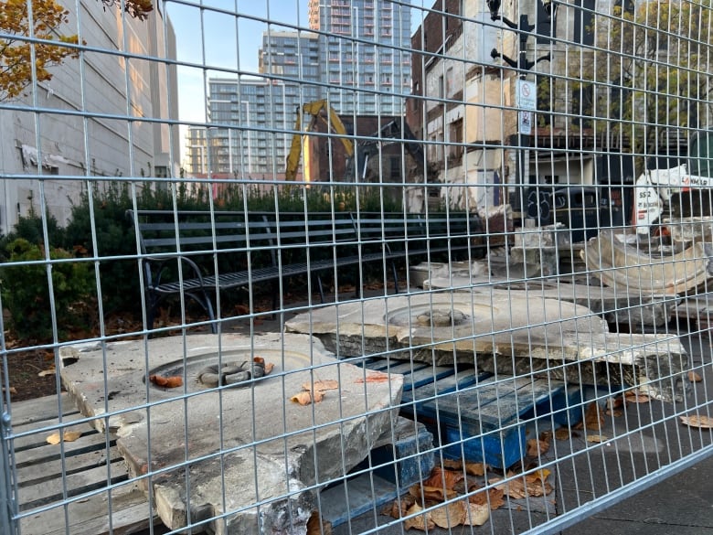 Pieces of concrete lay behind a fence. 