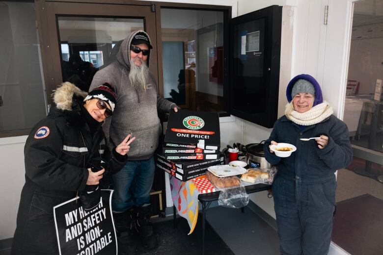 Canada post striking workers with pot luck style food inside