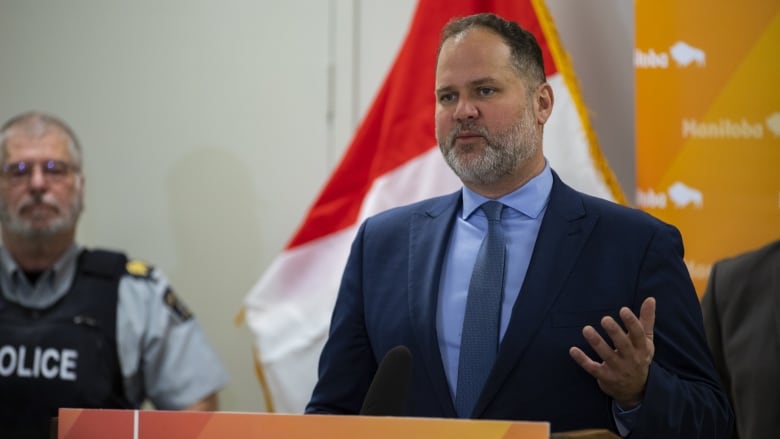 A man in a suit at a podium speaks.