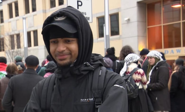 A young Black man smiles at a person off camera.