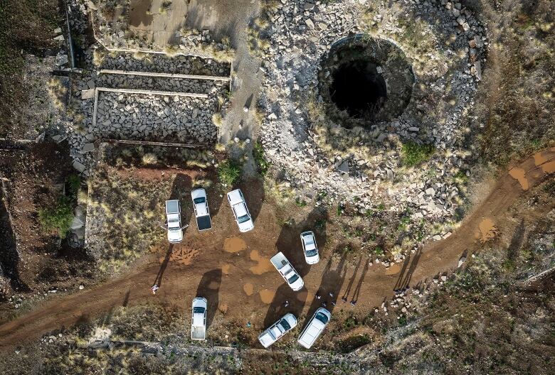 A large rocky hole in the ground, pictured from above.