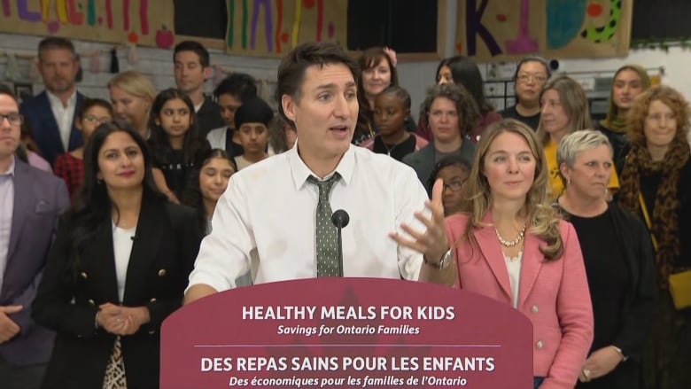 Prime Minister Justin Trudeau stands at a podium flanked by Families, Children and Social Development Minister Jenna Sudds, right, and Minister of Diversity, Inclusion and Persons with Disabilities, Kamal Khera, left.