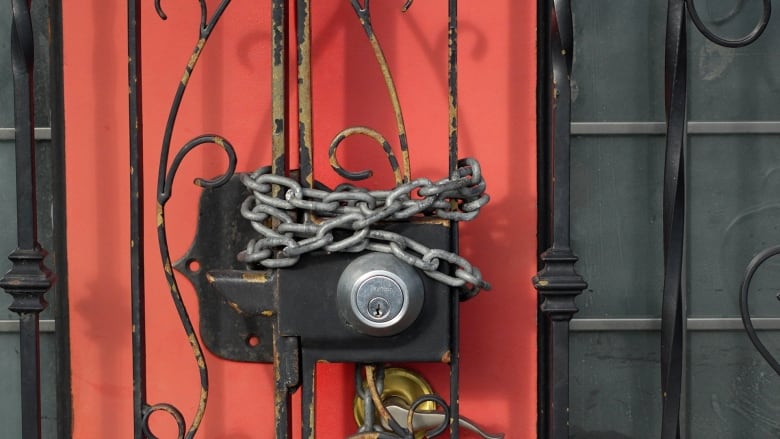 A lock and chain on the door of a building.