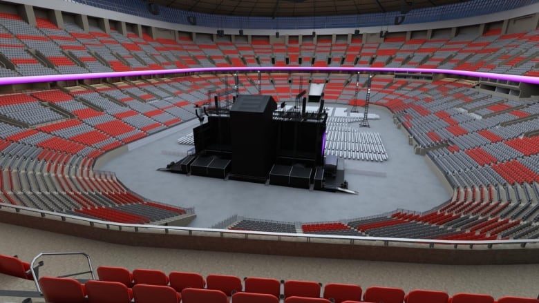 A view from a stadium shows a black stage and empty seats.